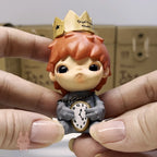 Hirono The Other One Small figurine of a character with a crown and clock, held between fingers.