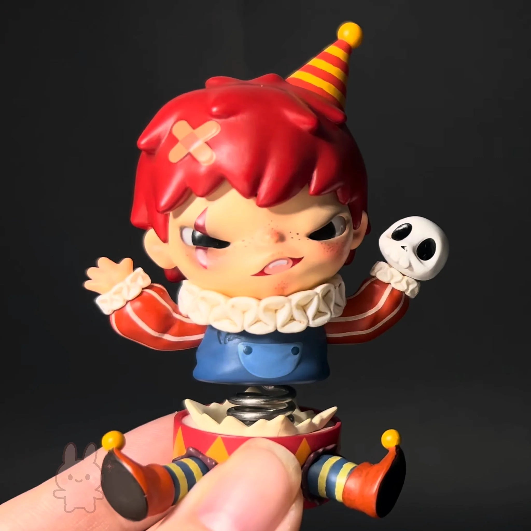 Hirono-monsters Toy figure of a clown with red hair and colorful outfit on a dark background