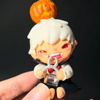 Hirono-monsters-carnival Small figurine with white hair and red eyes, holding a small pumpkin, against a dark background.