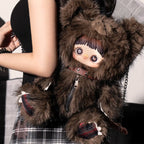 Brown Maymei Rebel Doll plush bag with a character design held by a person