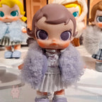 Baby Molly - Winter Fit Check Toy figure with a fluffy gray coat and checkered skirt, standing on a reflective surface.