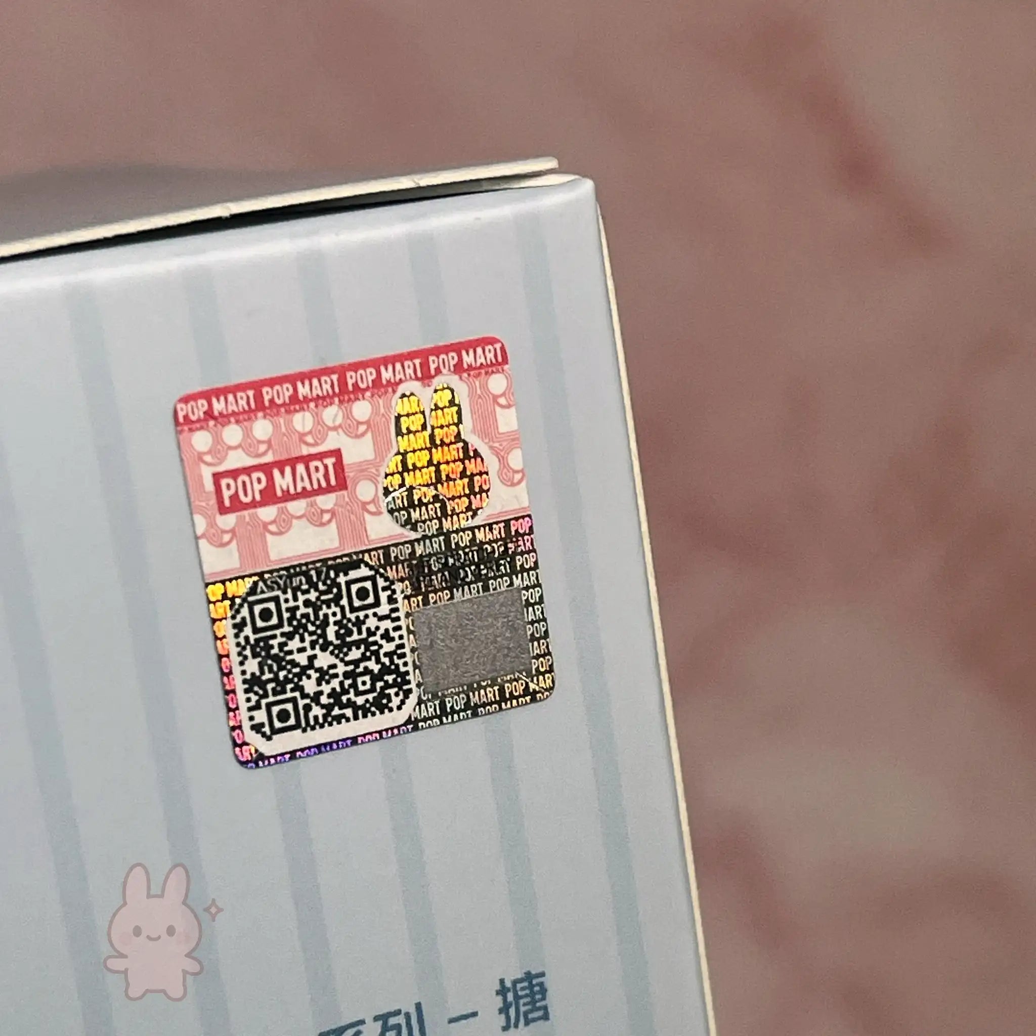 Labubu THE MONSTERS Sanrio Product packaging with a Pop Mart label and QR code on a blurred background