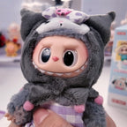 Labubu THE MONSTERS Sanrio Plush toy with a cat-like design held by a hand, with a blurred background