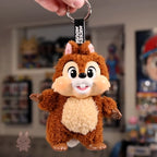 Plush keychain of a cartoon character held by a hand with a blurred background