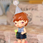 Pop Mart Hirono Echo Small figurine of a child with a party hat and striped shirt, held in hand.