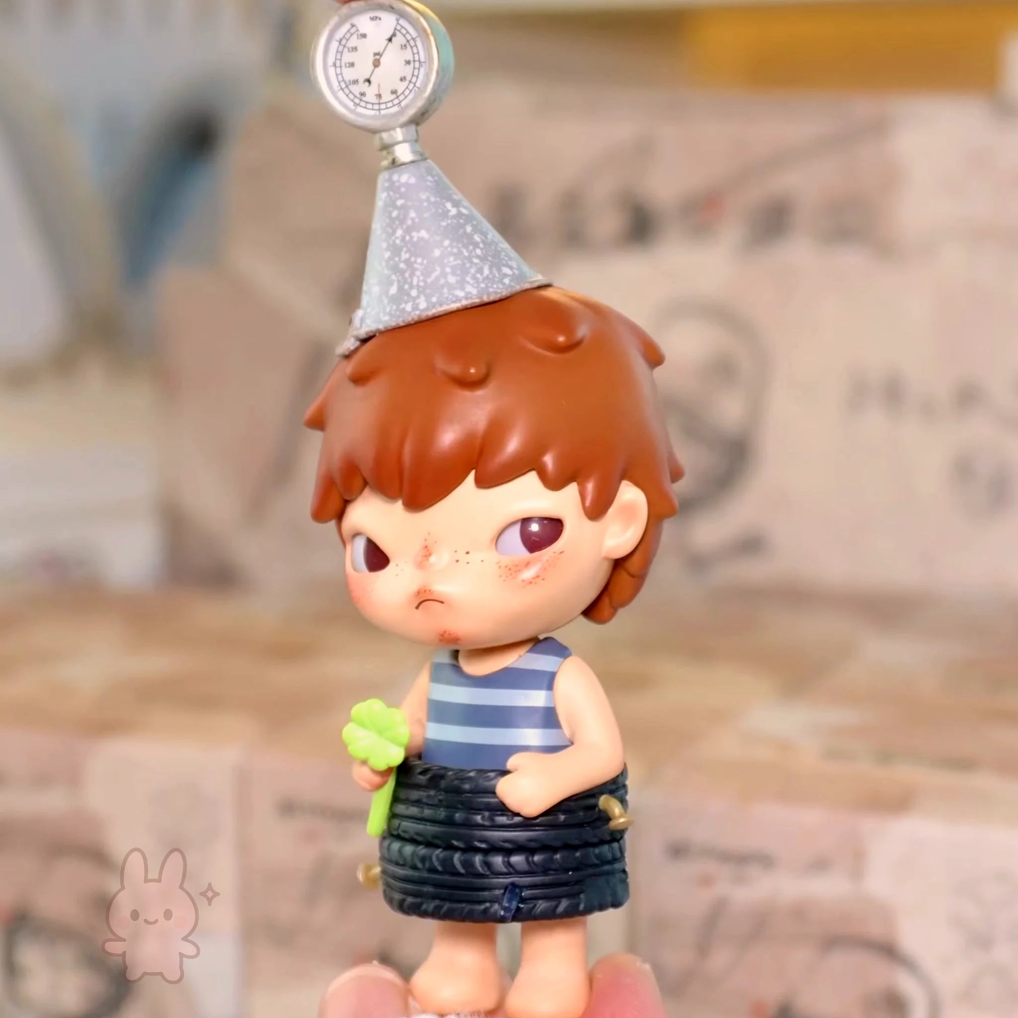 Pop Mart Hirono Echo Small figurine of a child with a party hat and striped shirt, held in hand.