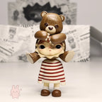 Pop Mart Hirono Little Mischief Figurine of a girl with teddy bear on her head against a newspaper background