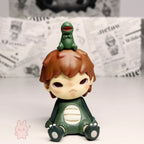 Pop Mart Hirono Little Mischief Toy figure of a boy with a dinosaur on his head against a newspaper background