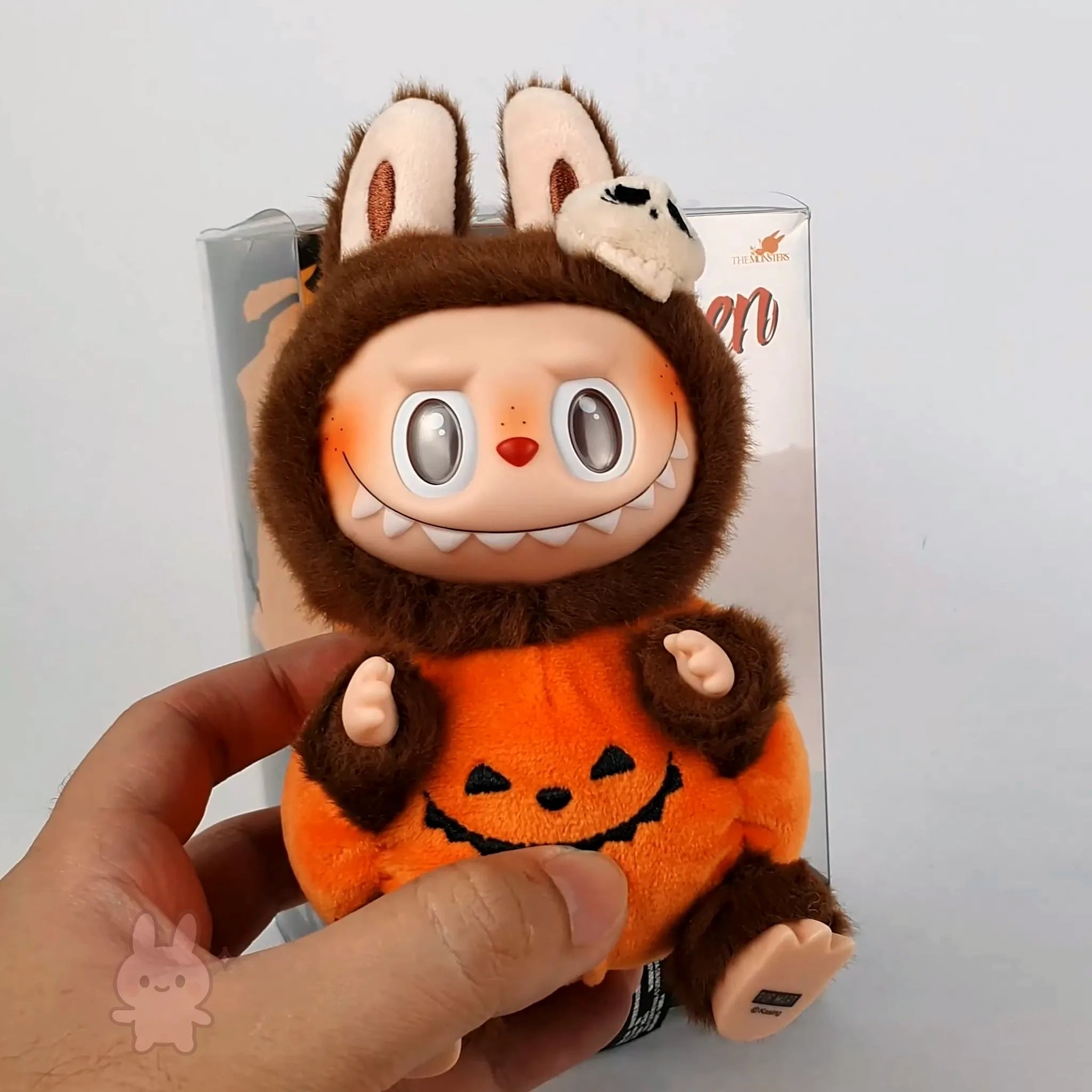 Pop Mart Labubu Halloween Plush toy with a Halloween design held by a hand against a plain background
