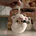 Pop Mart PUCKY Tap Tap Babies Plush keychain held by a hand with cartoon character packaging in the background
