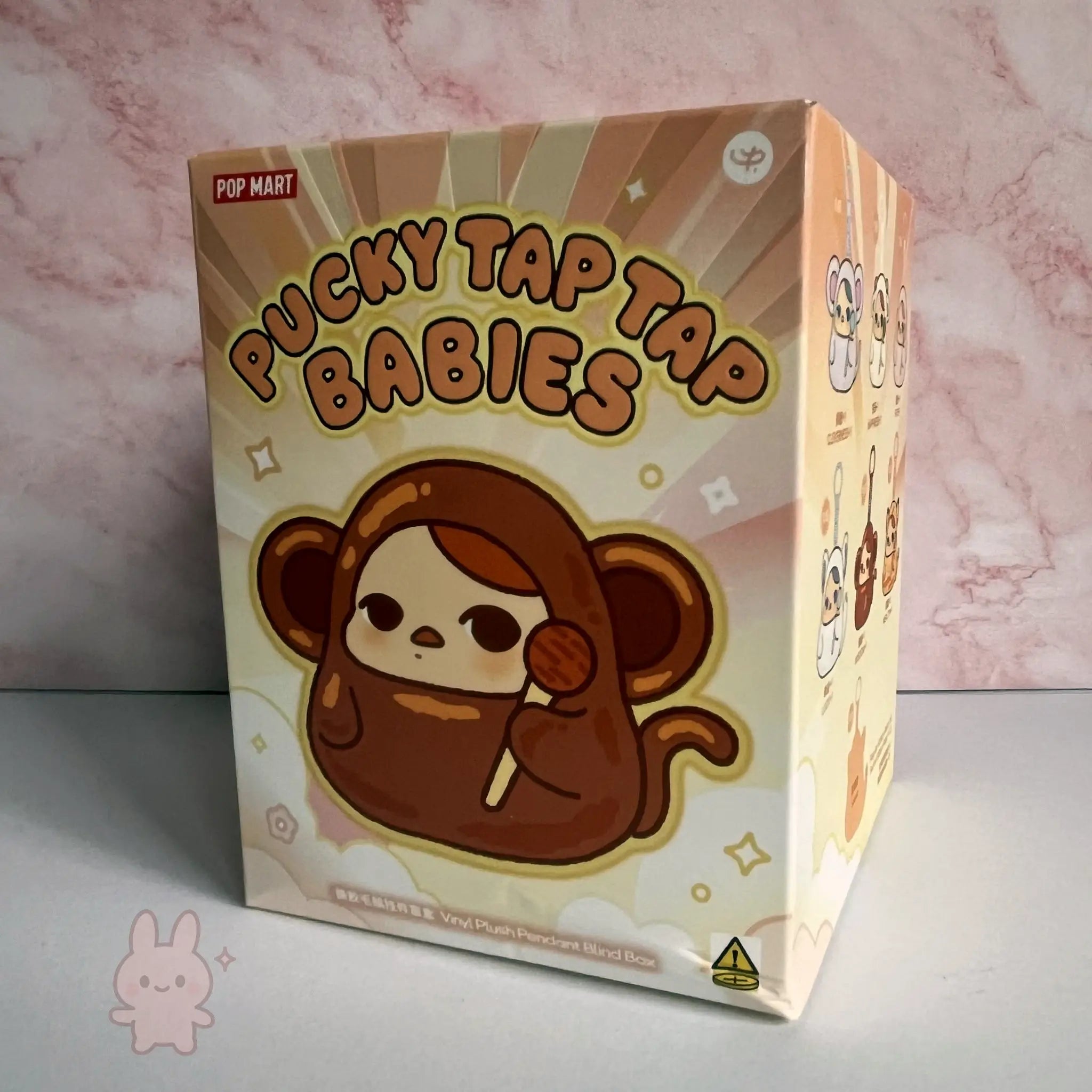 Pop Mart PUCKY Tap Tap Babies Box of Pucky Tap Tap Babies with a cartoon monkey design on a pink marble background
