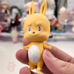 Pop Mart The Monsters 10th-anniversary Yellow cartoon-like figurine held in a hand with a blurred background
