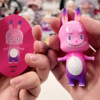 Pop Mart The Monsters 10th-anniversary Pink and purple toy rabbit held by a person, with a matching round card.