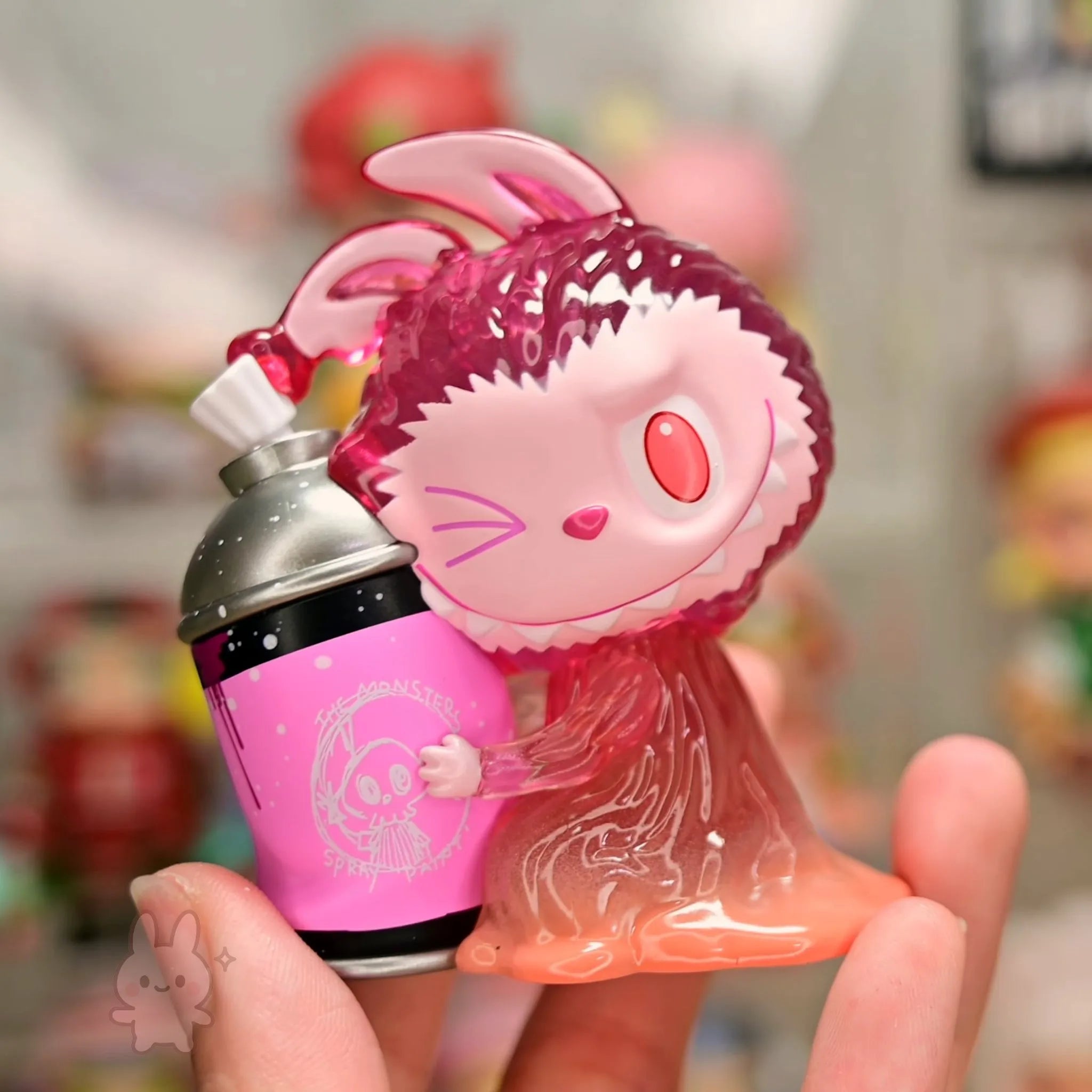 Pop Mart The Monsters Almost Hidden Pink and purple character figurine holding a pink cup with a straw, against a blurred background.