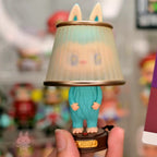 Pop Mart The Monsters Almost Hidden Small lamp with a cartoonish design held in front of a blurred background