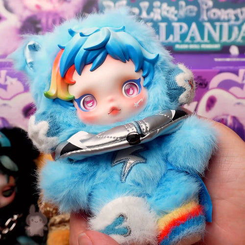 SKULLPANDA My Little Pony Plush Blue plush toy with rainbow accents held by a hand, with a colorful background.