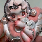 Skullpanda-the-feast-begins Cute figurine with pink and white colors held by a hand