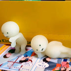 Smiski Two white figurines on a colorful book with a yellow background