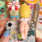 Sonny-Angel-hippers-animal with a decorative design held by a small yellow figure against a colorful background.