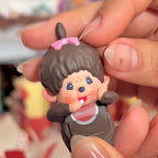 Monchhic hiippers Small figurine held in a hand with a blurred background