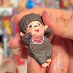 Monchhic hiippers Small figurine of a character with a blurred colorful background