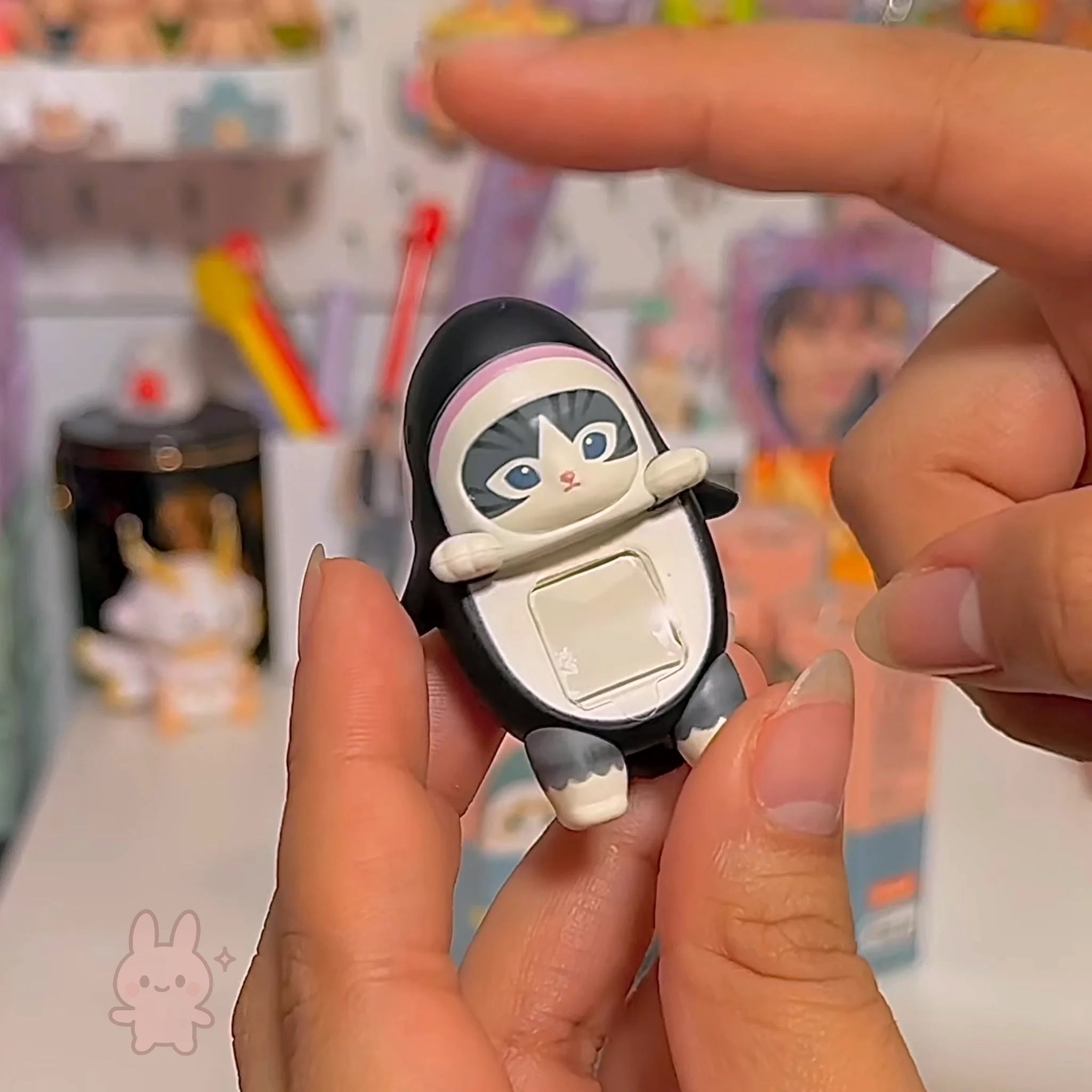 Sonny Angel Mofusand Hippers Small cat-shaped phone case held between fingers with a blurred background