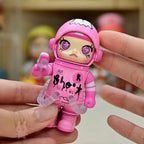 Space molly 100 series4 Pink toy figure with a stylized face held between two fingers against a blurred background
