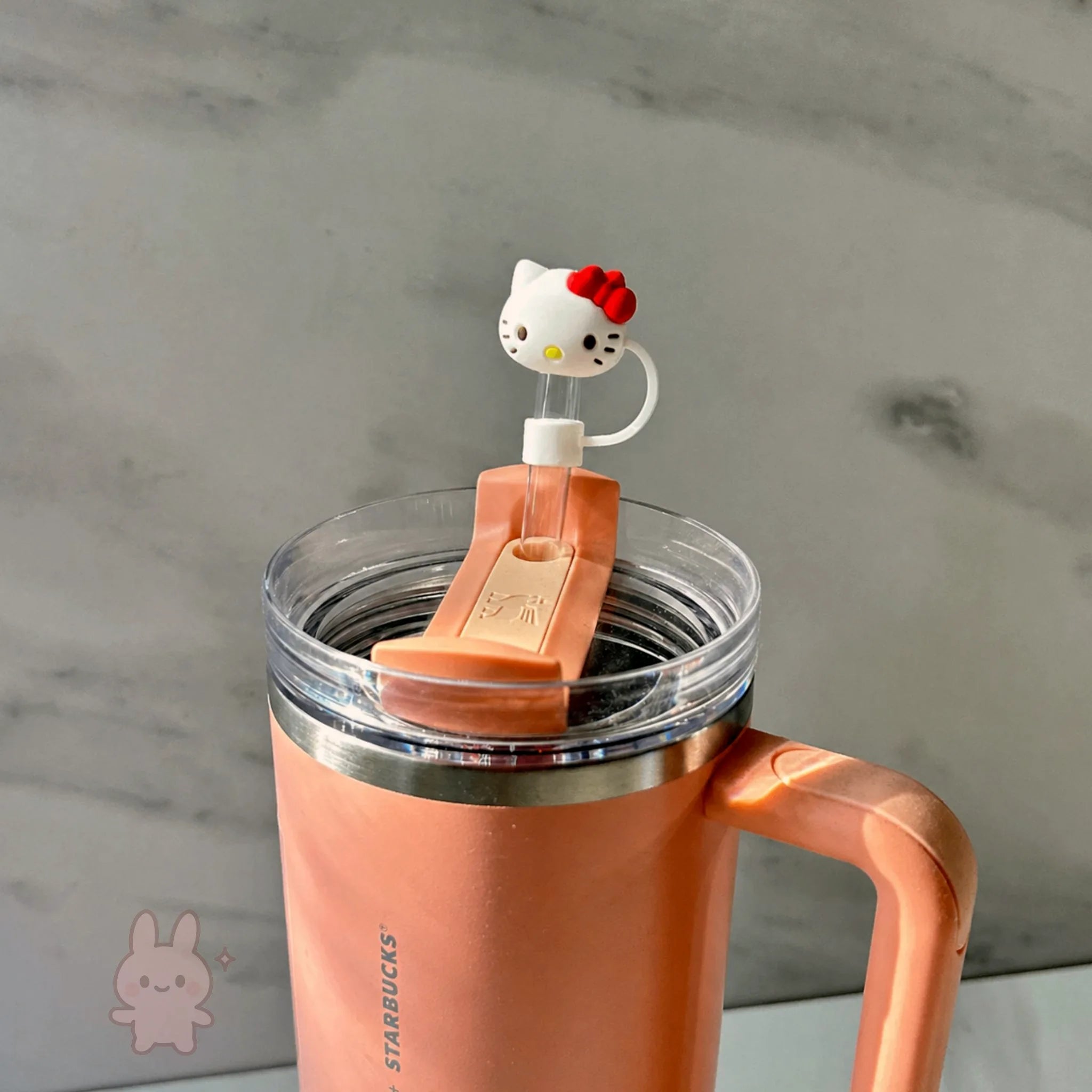 Starbucks tumbler with a Hello Kitty-themed straw lid on a neutral background