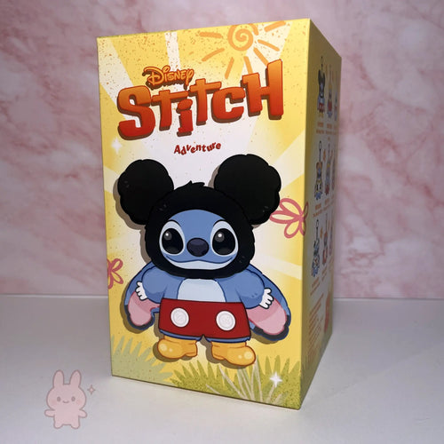 Stitch Adventure Plush Box featuring a character resembling Stitch from Disney with Mickey Mouse ears on a pink and white marbled background.