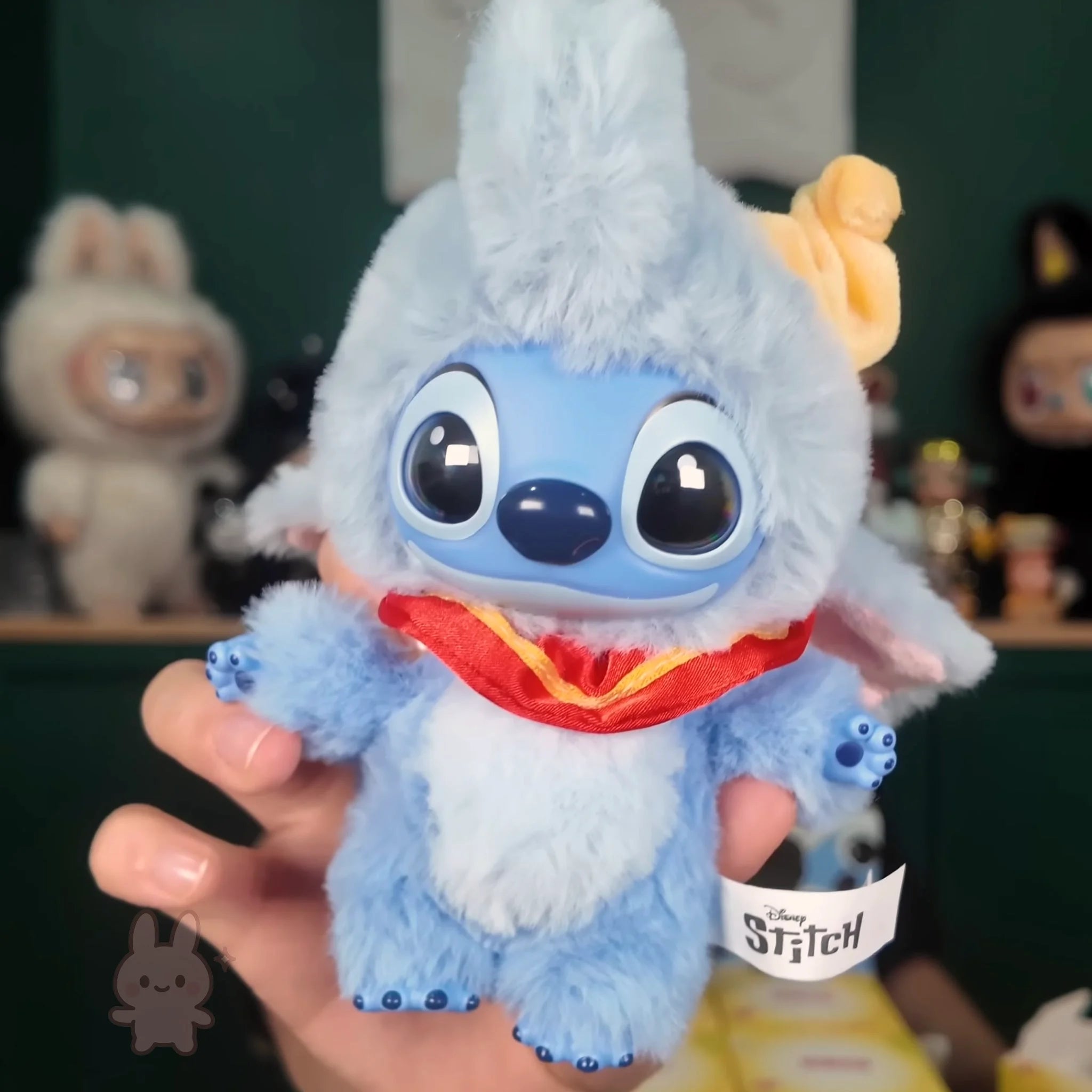 Stitch Adventure Plush toy resembling a character from a popular animated series held in a hand with blurred background