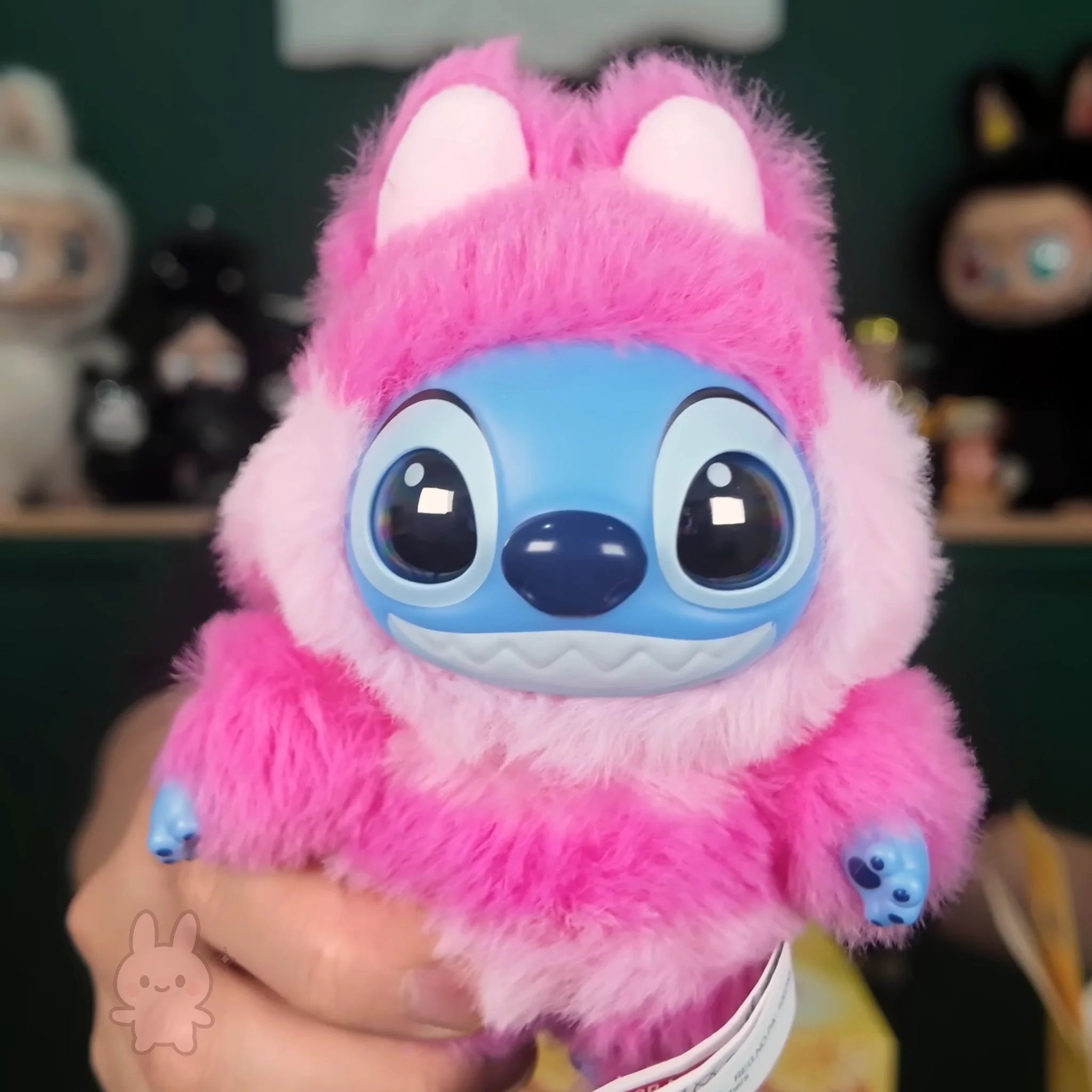 Stitch Adventure Plush Pink and blue plush toy resembling a character from a popular animated series, held in a hand with a blurred background.