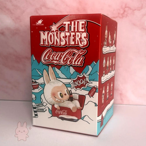 The Monsters Coca-Cola themed product packaging with a cartoon character on a pink background