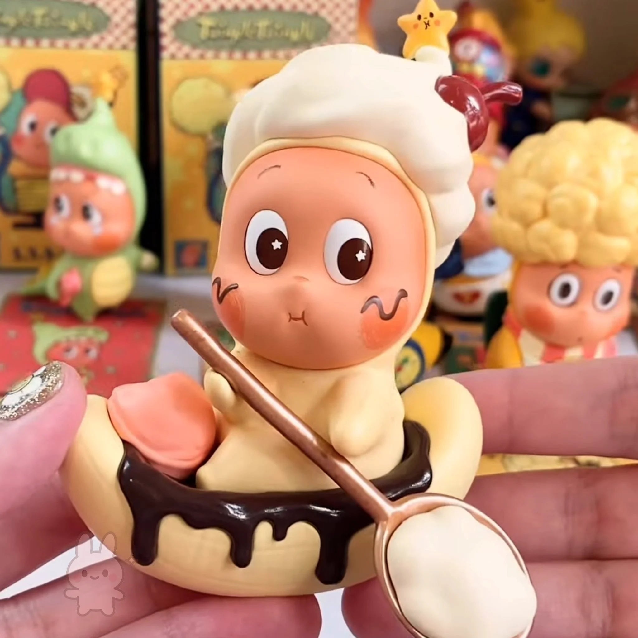 Twinkle Twinkle Be a Little Star Toy figure of a character with a spoon and dessert, held in a hand with a colorful background.