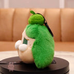 Plush toy shaped like a character with green fur and beige face on a round black platform.