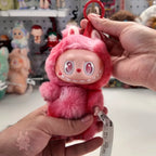 labubu-big-into-energy Pink plush keychain with a tag held by a hand in front of a store display.
