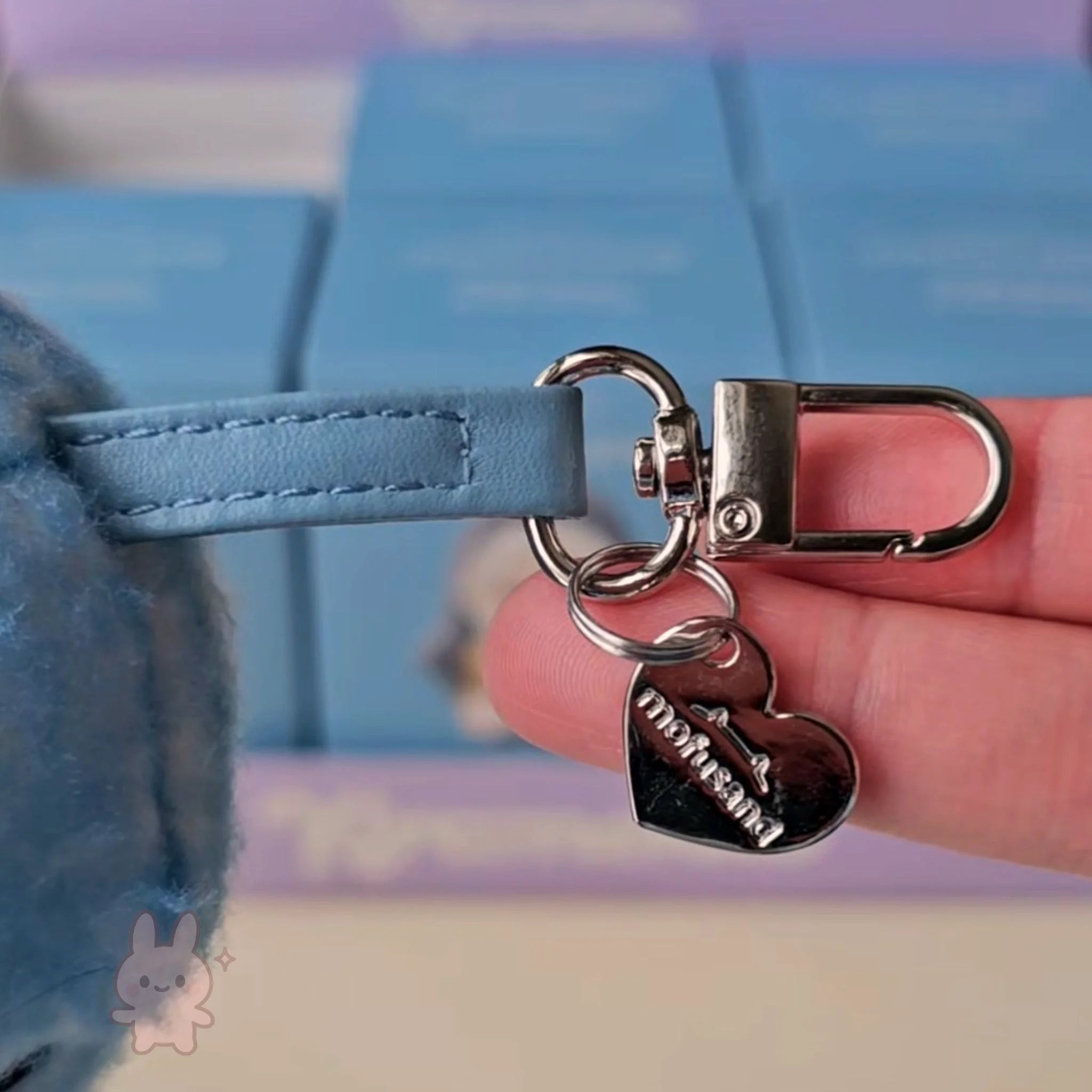 mofusand fluffy kittens Heart-shaped keychain with a lock charm held by a hand against a blurred background
