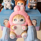 mofusand fluffy kittens Plush toy cat in a pink outfit held by a person with boxes in the background