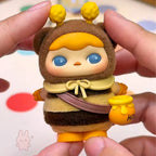 pucky faries market Toy figure of a bee character held between fingers with a colorful background