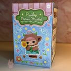 Pucky Fairies' Market toy packaging with a character holding flowers on a blue background.