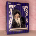 Toy figure in a box with 'Skullpanda Wednesday' branding on a pink background