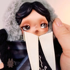 skullpanda Close-up of a doll with a fur-lined hood and a hand holding it by the chin.