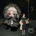Grey You Found Me plush character beside a model