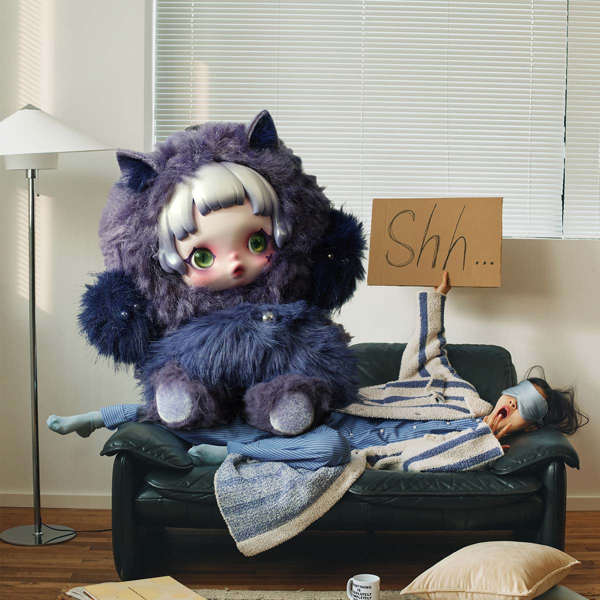 Purple You Found Me plush character holding a Shh sign