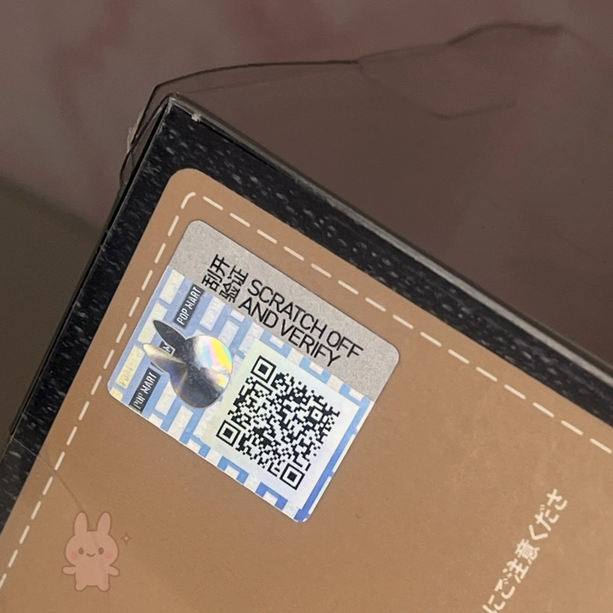 hirono Close-up of a brown card with a scratch-off label and QR code on a blurred background