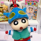 shinchan Plush toy of a cartoon character with a blue helmet and green outfit, standing in front of colorful background.