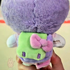 hello kitty Plush toy with a bow held by a hand on a light background