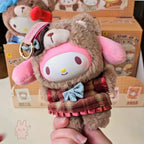 sanrio-afternoon Plush keychain with a cartoon character face, held by a hand in front of a box with more plush toys.