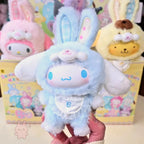 Sanrio characters Elf Bunny Baby Plush toy with bunny ears and a white face held in front of colorful boxes with cartoon characters.