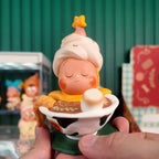 Twinkle Twinkle Savor the Moment Toy figure of a character with ice cream on top, held by a hand against a blurred background.